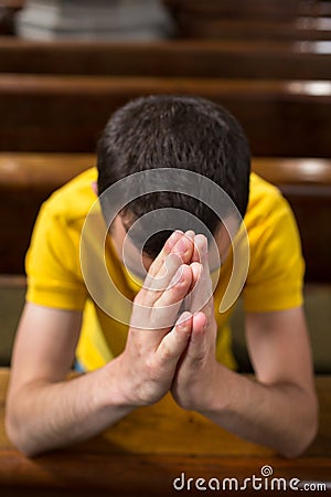 Young man praying in a church