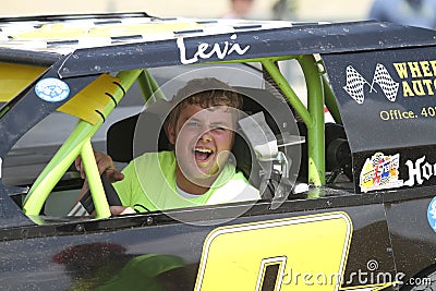 Young man in race car in a parade in small town America