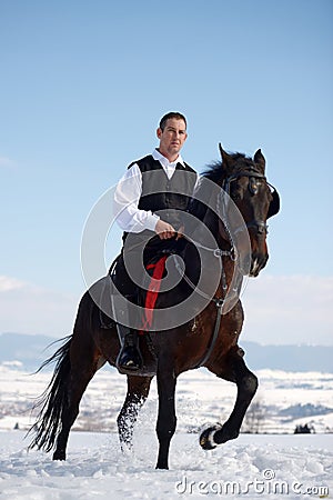 Young man riding horse outdoor in winter