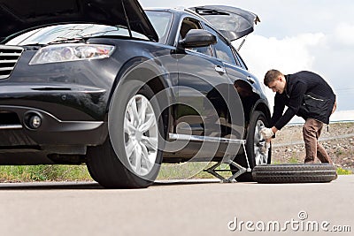 Young man with a roadside puncture