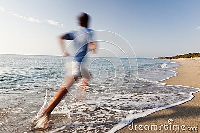 Young man running on a beach.
