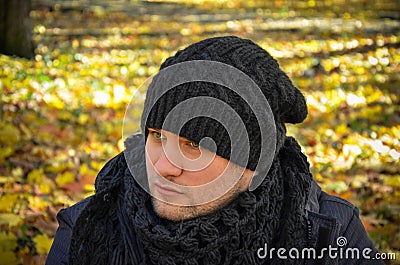 Young man with a sad look with autumn leaves