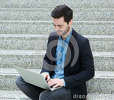 Young man smiling with laptop