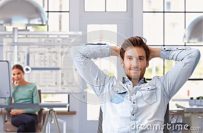 Young man taking break of work at architect office