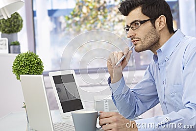 Young man thinking at desk