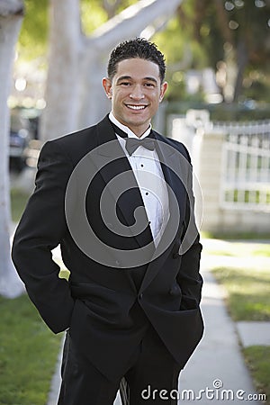 Young Man In Tuxedo Standing With Hands In Pocket At Quinceanera