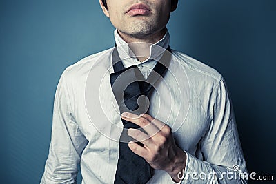 Young man tying his tie