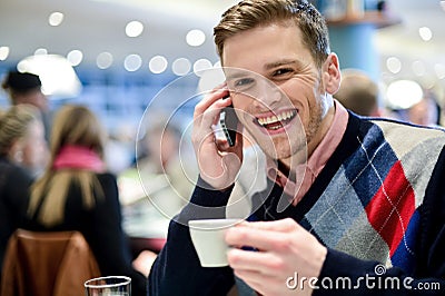 Young man using mobile phone in cafe