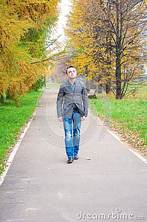Young man walking in autumn park