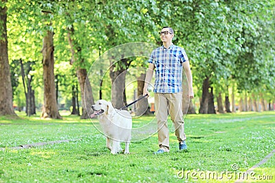 Young man walking his dog in a park