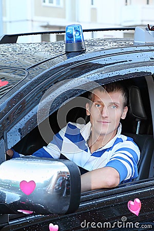 Man at wheel of wet offroader with stickers hearts