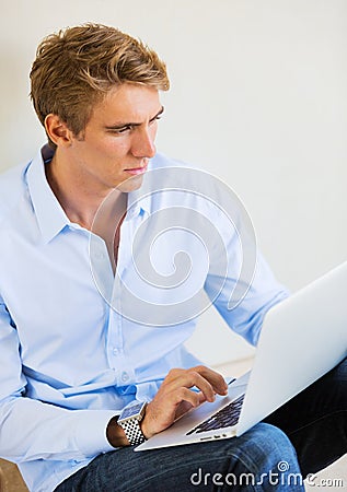 Young Man Working on Laptop Computer at Home