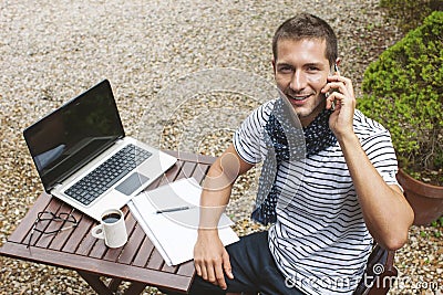 Young man working talking with smart phone in outdoors.