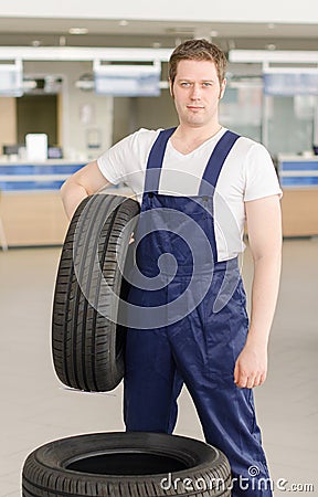 Young mechanic with tire.