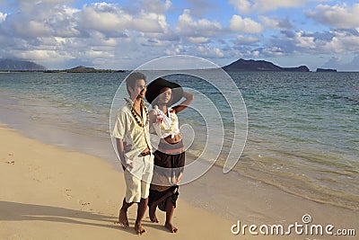 Young mixed couple walk on a beach