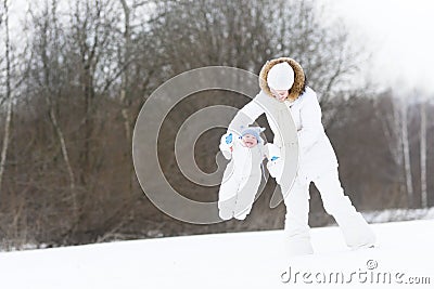 Young mother with her baby on snowy winter day