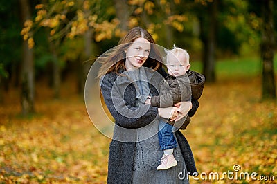 Young mother and her toddler daughter at fall