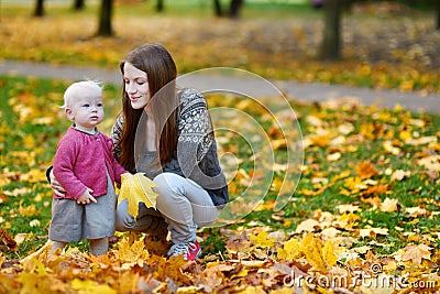 Young mother and her toddler daughter at fall