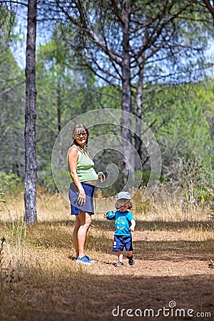 Young mother and son walking through woods