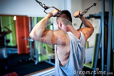 Young, muscular man, bodybuilder working out in gym
