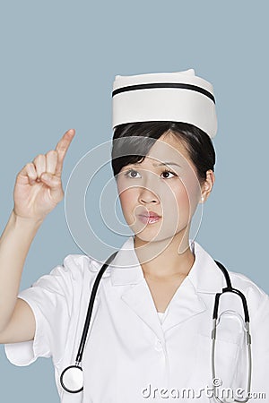 Young nurse using transparent screen over light blue background