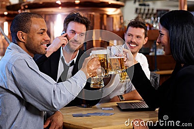 Young office workers toasting with beer at pub