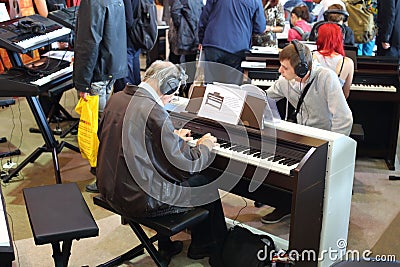 Young and old people playing the keyboards with headphones