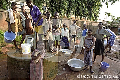 Young people fetch water at a water pump