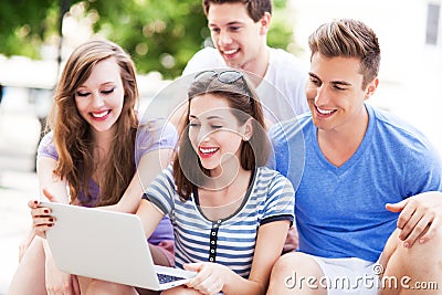 Young people with laptop outdoors