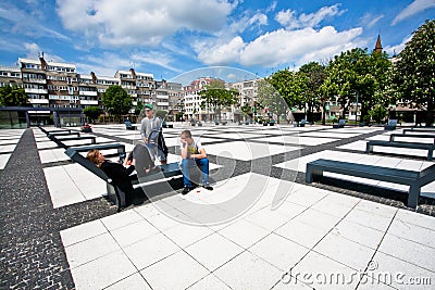 Young people relaxing in urban style city park under the white clods sky