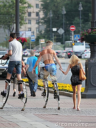 Young people walking on the street on a jumping stilts