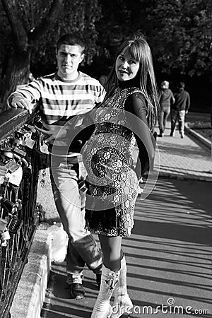 Young pregnant couple on bridge