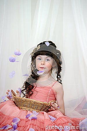 Young princess with pink dress with rose petals