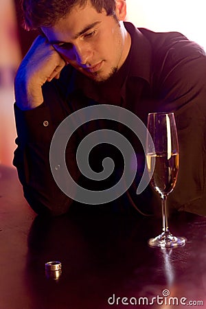 Young puzzled man with ring and champagne glass