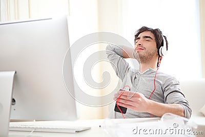 Young relaxed man listenning music at the office