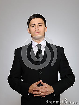 Young serious business man in black suit and tie