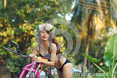 Young sexy Asian woman in black lingerie on pink motorcycle