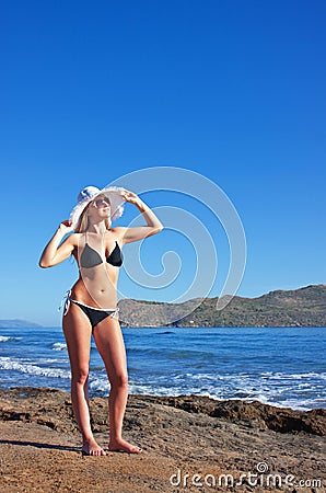 Young smiling blond woman in black bikini