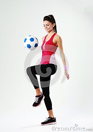 Young smiling woman playing with soccer ball