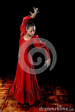 Young Spanish woman dancing flamenco in typical folk red dress