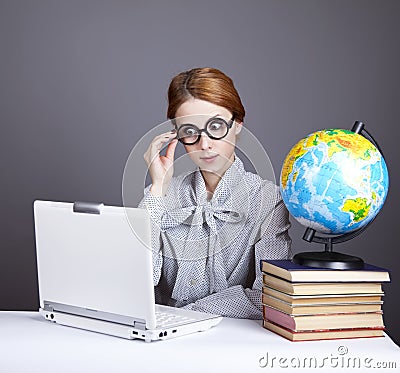 The young teacher with books, globe and notebook.
