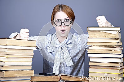 The young teacher in glasses with books.