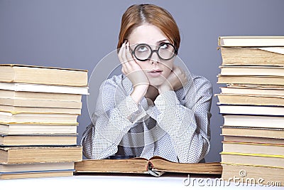 The young teacher in glasses with books.