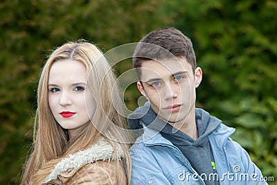 Young teenage couple posing back to back