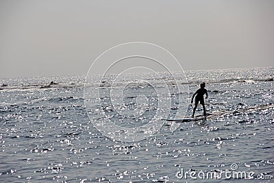 Young teenage girl learning surfing on ocean surf