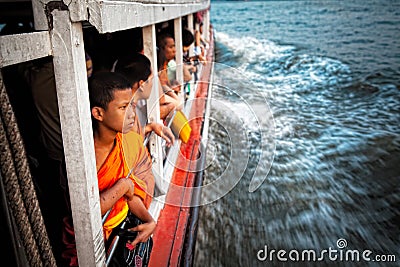 Young Thai monk takes a taxi boat