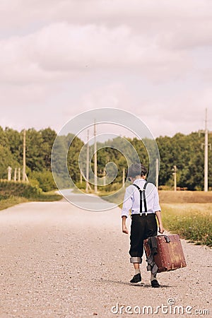 Young traveller walking away with suitcase