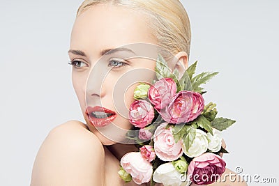 Young woman with beautiful face and flowers. Skin