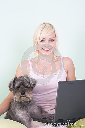 Young woman in bed with laptop and schnauzer do