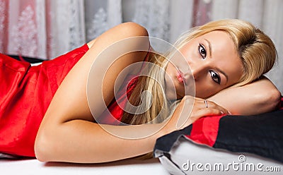 Young woman in bed in red underwear